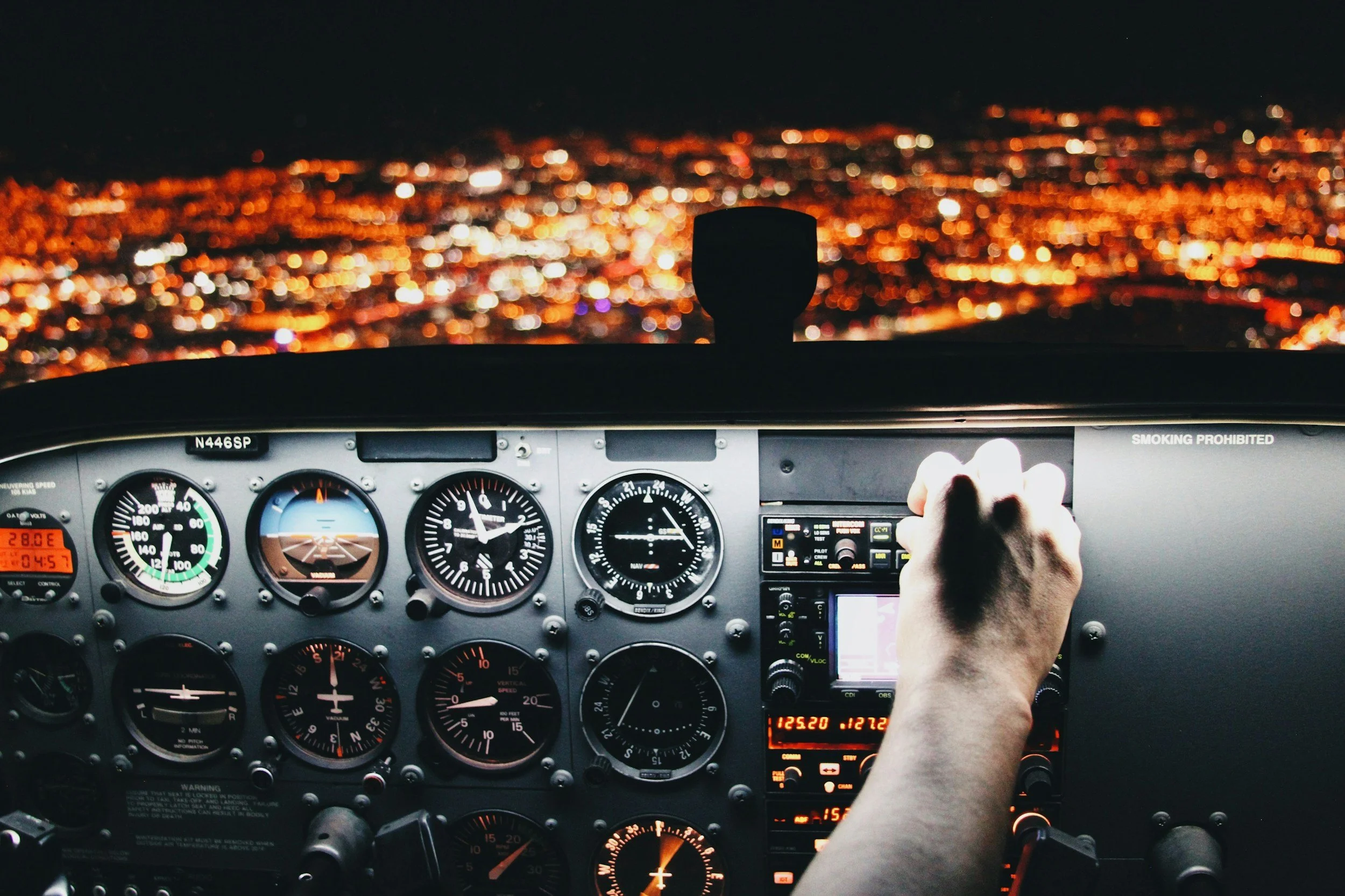 Aircraft instrument panel at night over city lights